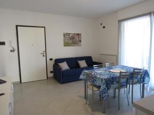 a living room with a table and a blue couch at Bludamare in Albenga