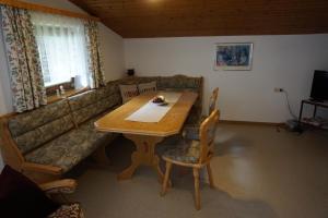 sala de estar con mesa de madera y sofá en Habachschmied Familie Gruber, en Bramberg am Wildkogel