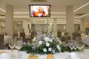 a dining room with a table with a vase of flowers at Hotel Paraiso Granada in Moraleda de Zafayona