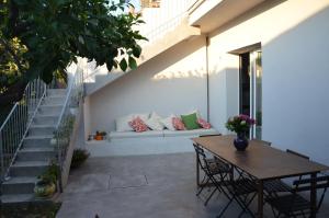 een patio met een bank en een tafel en stoelen bij Il nido di Ale in San Gregorio di Catania