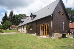 a large wooden house with a gambrel roof at Maison du Murphy in Sourdeval