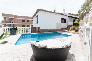 a swimming pool with a tub next to a house at Chalet Cerro in Peniscola
