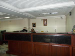 a woman sitting at a reception desk in a waiting room at Biju's Tourist Home in Cochin