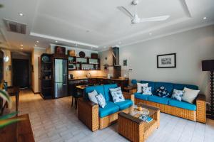 a living room with blue couches and a kitchen at Aquamarine in Eden Island