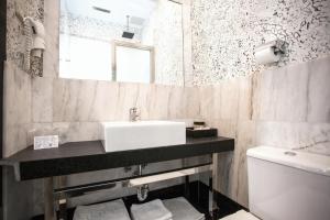 a bathroom with a sink and a toilet and a mirror at Alhambra Suites in Madrid