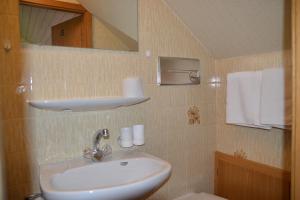 un bagno con lavandino e specchio di Haus Kärnten a Altossiach Altre 37 foto