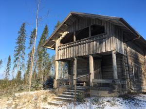 un vecchio edificio in legno nel mezzo di una foresta di Riihipiilo a Moksinkylä