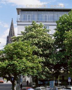 a tree in front of a building with a view of a city at Colombi Hotel in Freiburg im Breisgau