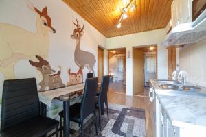 a kitchen with a table with animals painted on the wall at Apartment Luketić in Slunj