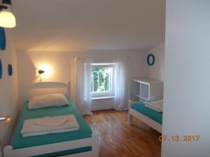 a small bedroom with two beds and a window at Apartments Blue Sea in Mali Lošinj