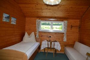 Piccola camera con letto, divano e finestra. di Haus Kärnten a Altossiach