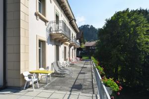 a balcony with chairs and tables on a building at Waldhotel Unspunnen in Interlaken