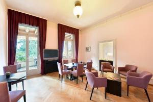a living room with a table and chairs and a television at Waldhotel Unspunnen in Interlaken