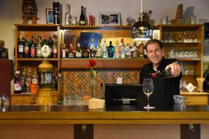 a man pouring a glass of wine at a bar at Waldhotel Unspunnen in Interlaken