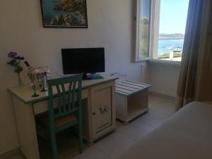 a room with a desk with a monitor and a chair at Hotel Nido D'aquila in La Maddalena
