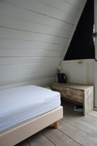 a bedroom with a bed and a wooden bench at Camping Yn'e Lijte in Grou