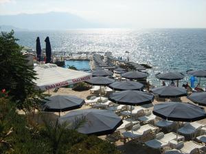 a group of umbrellas and chairs on a beach at Apartments Draga in Budva