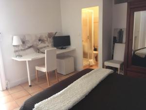 a bedroom with a bed and a desk with a computer at Villa Cemaste in Montpellier