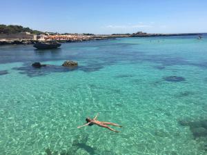 a person laying in the water in the ocean at Casa Paola in Favignana