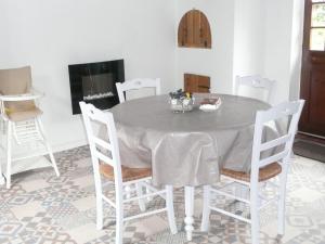 una sala da pranzo con tavolo e sedie di Rose Cottage En Baie De Somme a Nouvion-en-Ponthieu Altre 7 foto