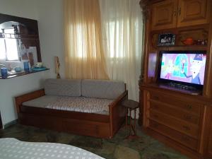 ポリフロノにあるMaria's beach houseのベッドルーム1室(ベッド1台、キャビネット内のテレビ付)