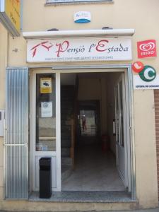 una entrada frontal a una tienda de comida rápida con un cartel en Pensió L'Estada, en Sant Joan les Fonts