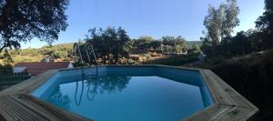 uma piscina com vista para uma colina em Azeite de Marvão, Olivoturismo casa Mestre do Lagar em Marvão