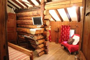 Zimmer in einem Blockhaus mit einem TV an der Wand in der Unterkunft Stadel Soussun in Champoluc