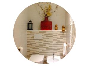 a bathroom with a white toilet and a red vase at Florivana Boutique Hotel in San Pietro in Cariano