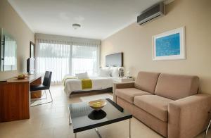 a hotel room with a bed and a couch at Sunset Apartments in Podstrana