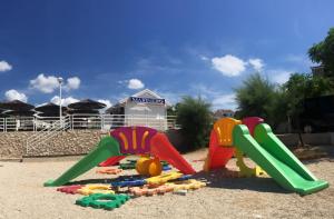 a playground with three play equipment in the sand at Apartments Matkovic in Vir