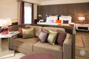a living room with a couch and a bed at Hôtel de Paris Saint-Tropez in Saint-Tropez