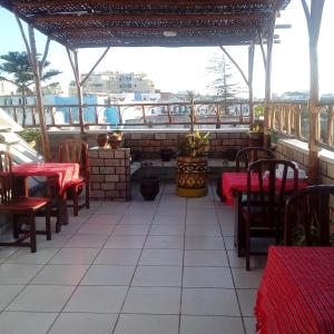 a patio of a restaurant with red tables and chairs at Riad Larache in Larache