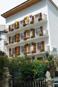 un edificio blanco con balcones y flores. en Hostal Pirineos Meliz, en Bielsa