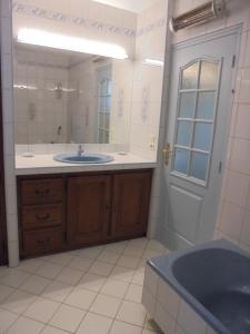 een badkamer met een wastafel en een grote spiegel bij Chez Aline in Salles-dʼArmagnac