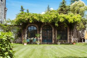 kamienny dom z niebieskimi drzwiami i bluszczem w obiekcie Villa Fava w mieście Montagnana