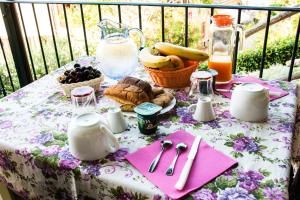 a table with a pink and white table cloth with food on it at B&B Borgo Marano in Cupra Marittima