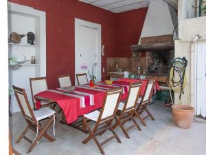 a dining room with a table and chairs with red walls at Villa Cemaste in Montpellier