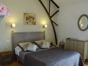 sypialnia z 2 łóżkami i lustrem na ścianie w obiekcie Domaine de la Guignardière w mieście Viévy-le-Rayé