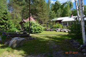 a yard with a house and a garden with a house at Lomakoti Tuulensuoja in Kärväsjärvi