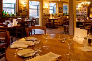 a wooden table in a restaurant with glasses on it at Gästezimmer der Adler Wirtschaft in Hattenheim