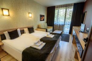 een hotelkamer met een groot bed met handdoeken erop bij Complex Jitari in Zhitnitsa