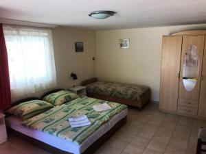 a bedroom with two beds and a cabinet at Gitta Apartmanház in Zalakaros