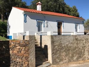 a small white house with a stone wall at Azeite de Marvão, Olivoturismo casa Mestre do Lagar in Marvão