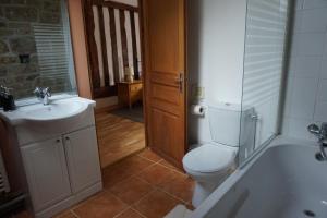 a bathroom with a toilet and a sink and a tub at Maison du Murphy in Sourdeval