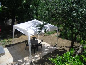トラモンティにあるLe Terrazze sui Montiの白い傘下のテーブルと椅子