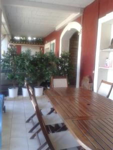 a wooden table and chairs in a room with potted plants at Villa Cemaste in Montpellier