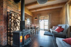 a living room with a fireplace and a table at MAZURY chillout in Ryn