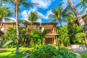 una casa con palmeras delante en Vila Coqueiros Boutique Hotel, en Cumbuco