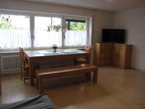 a living room with a table and a television at Ferienwohnung Dettenhausen in Dettenhausen